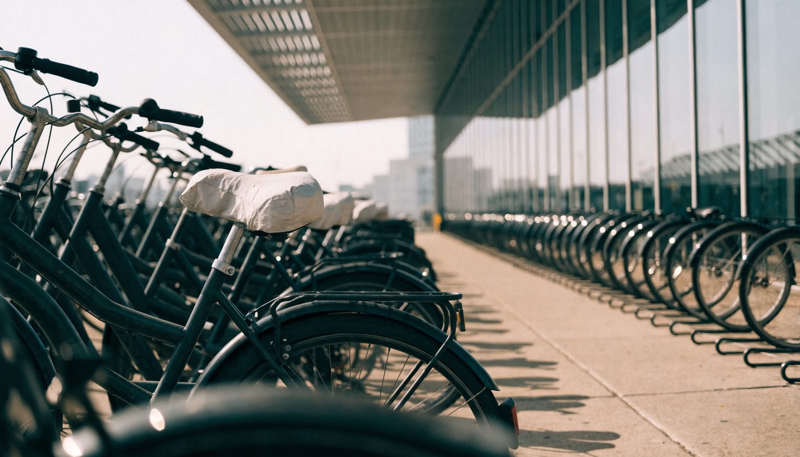 Lange Reihe geparkter Stadträder mit Sattelbezügen an einem Fahrradständer