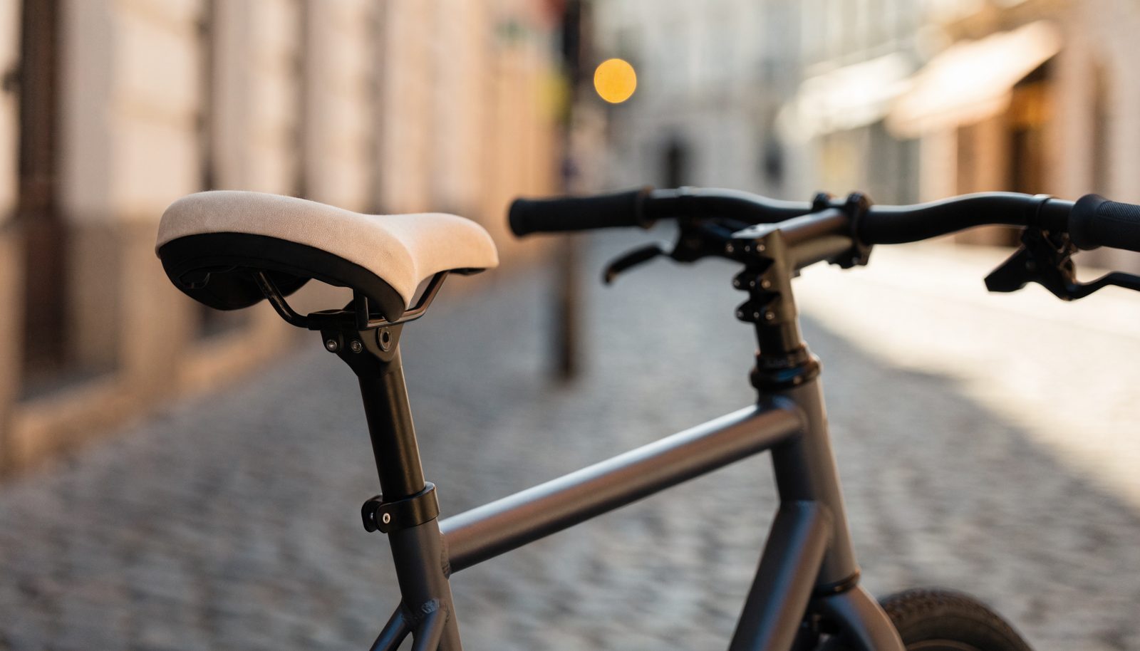 Stadtfahrrad mit bedrucktem Sattelbezug auf einer Kopfsteinpflasterstraße
